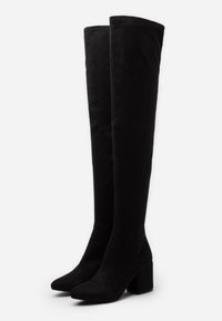 Botas negras hasta la rodilla hechas de tela suave, con un tacón cuadrado y un diseño de punta afilada. Textura lisa con parte superior elástica.