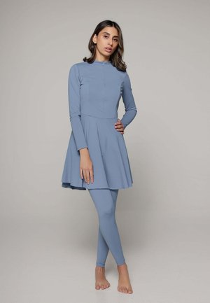Robe longue à manches longues bleu clair avec un corsage ajusté et une jupe évasée, accompagnée de leggings assortis. Tissu lisse avec un léger éclat.