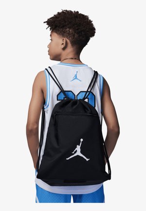 Čierny batoh na šnúrku s bielym logom Jumpman, vyrobený z odolnej tkaniny. Obsahuje nastaviteľné popruhy a predné vrecko na zips.