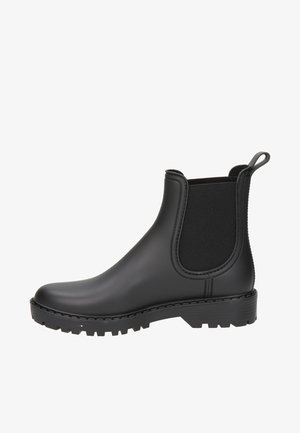 Zwarte rubberen enkelboot met elastische zijpanelen, ronde neus, gestructureerde zool en achterste trekband voor gemakkelijk aan- en uittrekken. Gladde afwerking.