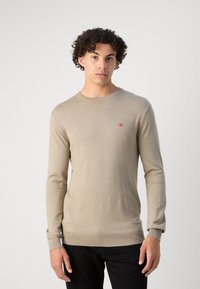 Beige Strickpullover mit langen Ärmeln, Rundhalsausschnitt, gerippten Bündchen und Saum. Besitzt ein kleines rotes Logo auf der Brust. Glatte Textur.