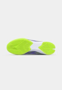 La suola della scarpa presenta un vivace gomma verde neon con motivi testurizzati e una sezione centrale bianca, compreso un distintivo design a punta divisa.