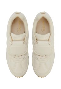 Beige Sneakers mit glatter Textur, ausgestattet mit einem Klettverschluss, Schnürsenkeln und einem goldenen Logo innen. Abgerundete Spitze und gepolsterte Sohle.