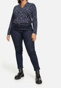 Námořnický dlouhý rukáv s leopardím potiskem, v kombinaci s tmavými skinny džíny a černými platformovými botami.