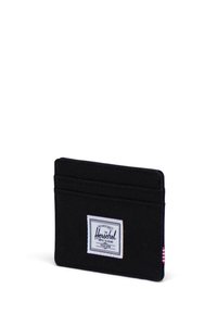 Black fabric cardholder with a white Herschel label, featuring four slots for cards and a red and white striped tag on the side.