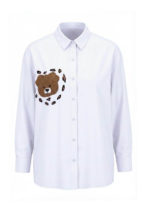 Camisa blanca de manga larga con botones y un bordado de cara de oso de peluche en el pecho, rodeada de manchas de estampado de leopardo.