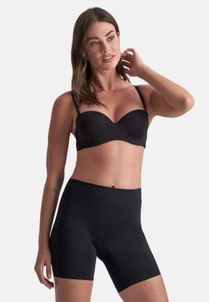 Zwarte naadloze bh met een gladde afwerking en beugel, gecombineerd met hoge zwarte shapewear shorts. Beide zijn strak en rekbaar.
