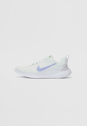 Valkoinen Nike-juoksukenkä, jossa vaalean violetti swoosh-logo, verkkomateriaalia ylempänä ja joustava valkoinen pohja, kuvattuna oikealta sivulta neutraalilla taustalla.