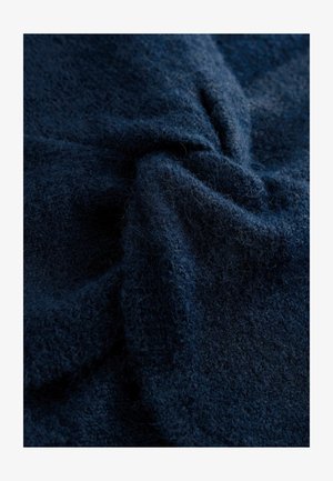 Jūras spēku tumši zils faktūrēts audums, mīksts un pūkains, ar nelielu spīdumu. Materiāls ir ar smalku auduma rakstu, kas rada dziļumu un vizuālu interesi.