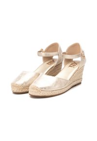 Esparraguera de plataforma de metal dorado con parte superior tejida, correa al tobillo, puntera redondeada y tacón envuelto en yute. Textura suave en toda su superficie.