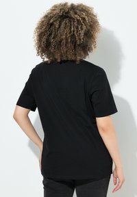 Zwarte katoenen T-shirt met korte mouwen, een klassieke ronde hals en een ontspannen pasvorm. Soepele textuur en eenvoudig ontwerp.