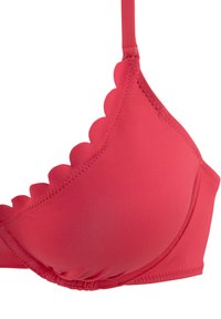 Červený bikiny top so zúbkovanými okrajmi, vypchávkami a nastaviteľnými popruhmi; hladká textúra s prešívaním pozdĺž švov.