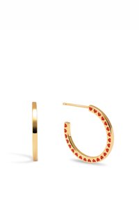 Boucles d'oreilles en or en forme de créole avec des accents en forme de cœur rouge le long du bord, mettant en valeur un design épuré et une finition métallique lisse.