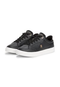 Sneaker in pelle nera con finitura liscia, dettagli dorati e suola in gomma bianca a contrasto; presenta punta rotonda e design con lacci classico.