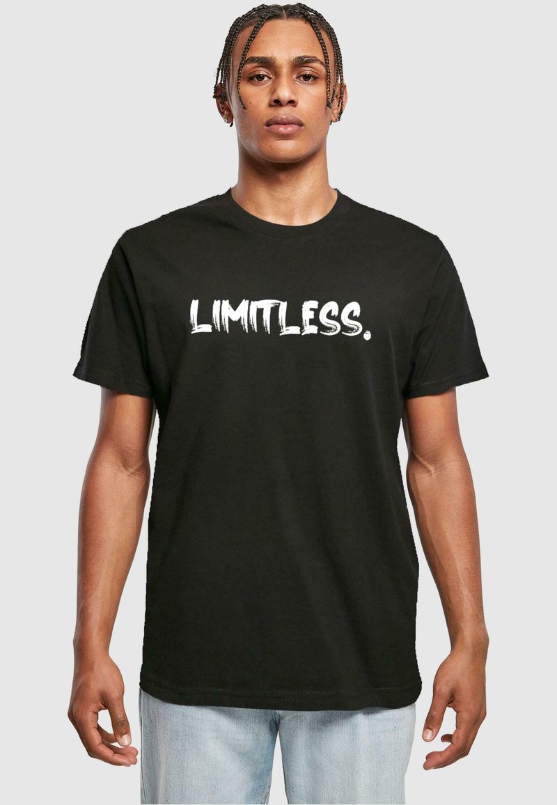 Svart bomull t-skjorte med ordet "LIMITLESS." i fet hvit, teksturert font; kort erm og rund halslinning.