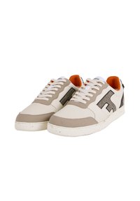 Sneakers beige e crema con un design perforato, accenti testurizzati, lacci bianchi e un interno arancione. Logo distintivo sul lato.