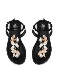 Sandales noires avec un design à large bride, ornées de coquillages décoratifs et d'une perle en accent sur le bout. Texture lisse avec une semelle plate.