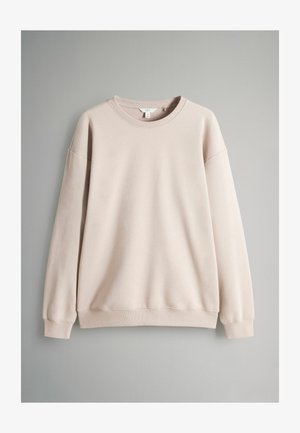 Lys beige sweatshirt lavet af blødt stof. Har en rund halsudskæring, lange ærmer, ribbede manchetter og kant med en afslappet pasform.
