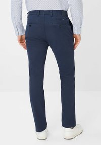 Marineblauwe chinos met een slim fit, voorzien van een soepele textuur, voor- en achterzakken, en stiksels dichtbij de tailleband.