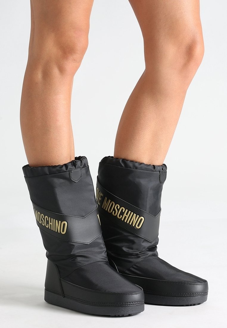 Schwarze isolierte Stiefel aus glattem Nylon mit einem umgeschlagenen oberen Teil, ausgestattet mit einer glänzenden schwarzen Sohle und einem schimmernden goldenen "Love Moschino"-Logo.
