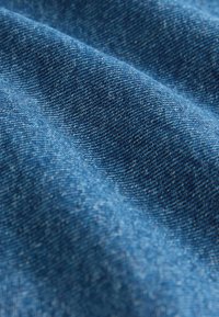 Tkanina z tkaného denimu v bohatom modrom odtieni, s hladkou textúrou a jemnými variáciami farby a klasickým zvislým vzorom.