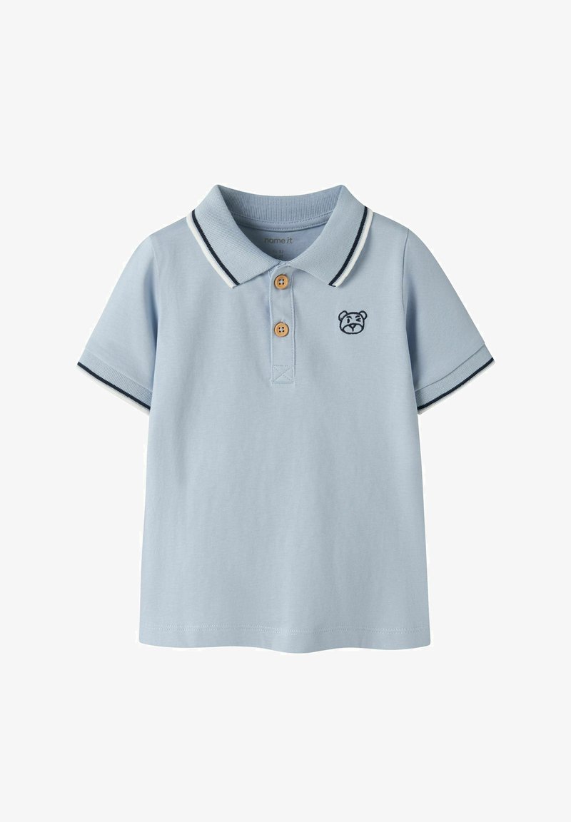 Polo a maniche corte azzurro chiaro con due bottoni marroni, rifiniture blu navy e bianche su colletto e maniche, e un piccolo volto di orso ricamato sul petto.