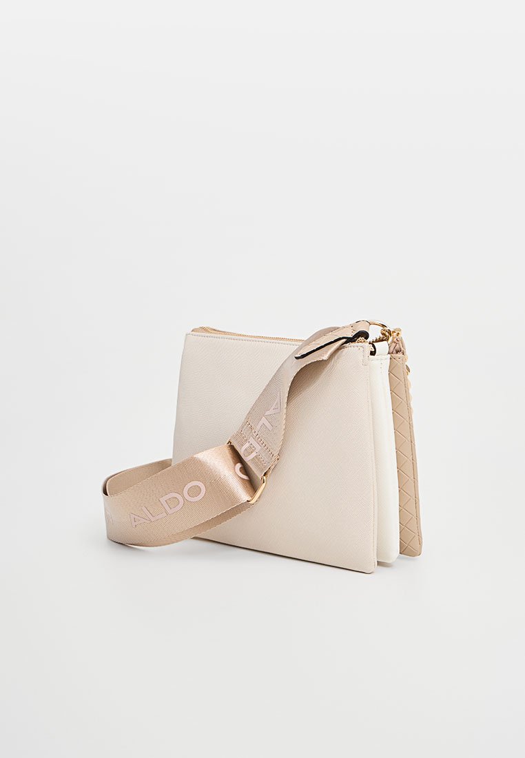 Beige Umhängetasche mit zwei Fächern und einem breiten, verstellbaren Schulterriemen, der mit "ALDO"-Schriftzug in hellrosa Buchstaben versehen ist.