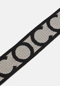 Černý tkaný pásek s výrazným šedým logem. Texturovaný povrch, plochý design, vhodný pro neformální i formální nošení.