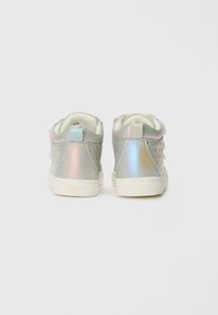 Witte en iriserende sneakers met een gladde textuur, geperforeerd ontwerp en drie decoratieve banden aan de achterkant.