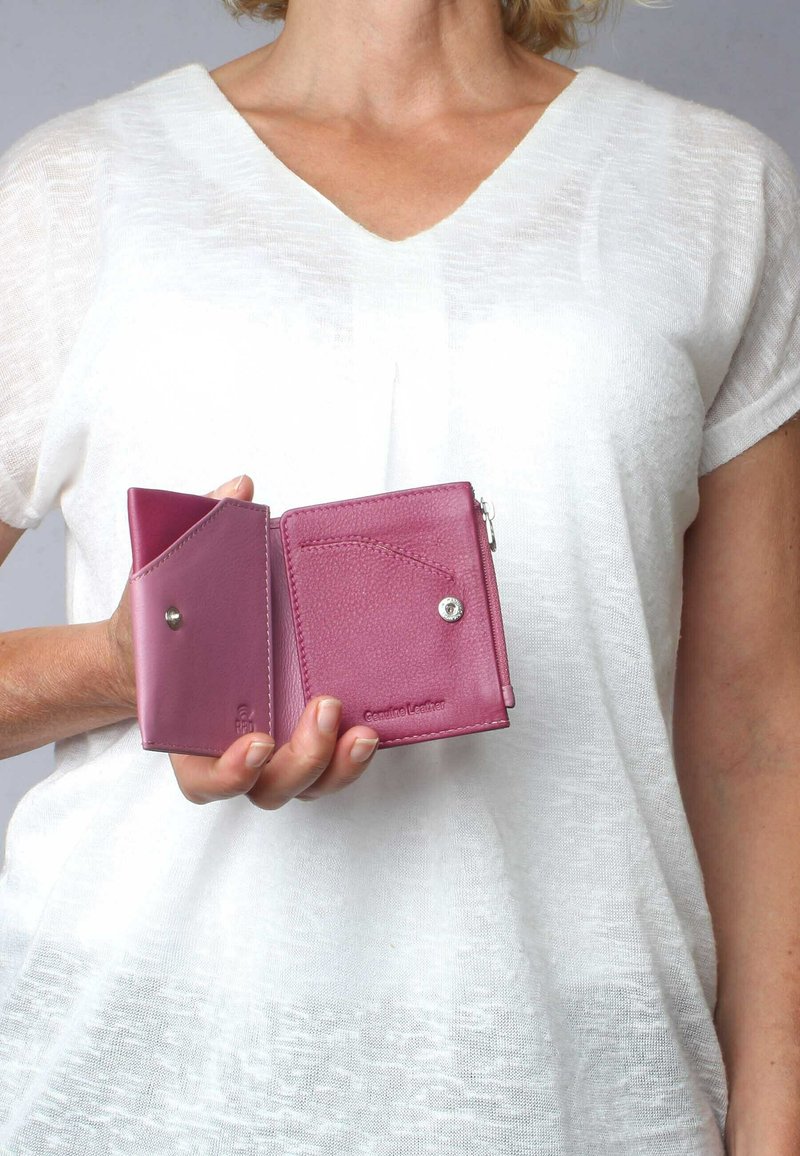 Rosa Lederbörse mit strukturierter Oberfläche, ausgestattet mit einem Druckknopfverschluss und einem Innenfach. Kompakte Gestaltung, die in der Hand gehalten wird.
