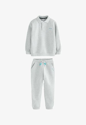 Šedá bavlnená mikina s golierom a dlhými rukávmi, skombinovaná s rovnakými teplákmi s bočnými vreckami a sťahovacím pásom.