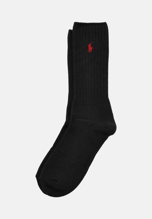 Black ribbed socks featuring a red logo. Knitted pattern, mid-calf length, soft texture, and reinforced toe and heel details.