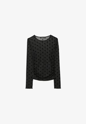 Schwarzes langärmliges Oberteil aus transparenter Stoff mit erhöhten Samt-Punkten. Verfügt über einen runden Halsausschnitt und geraffte Seitendetails.