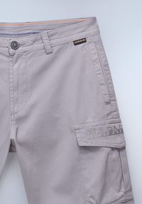Lysegrå cargo shorts med en glat tekstur, der har en lomme med prægede detaljer og kontrastsyninger på taljen.