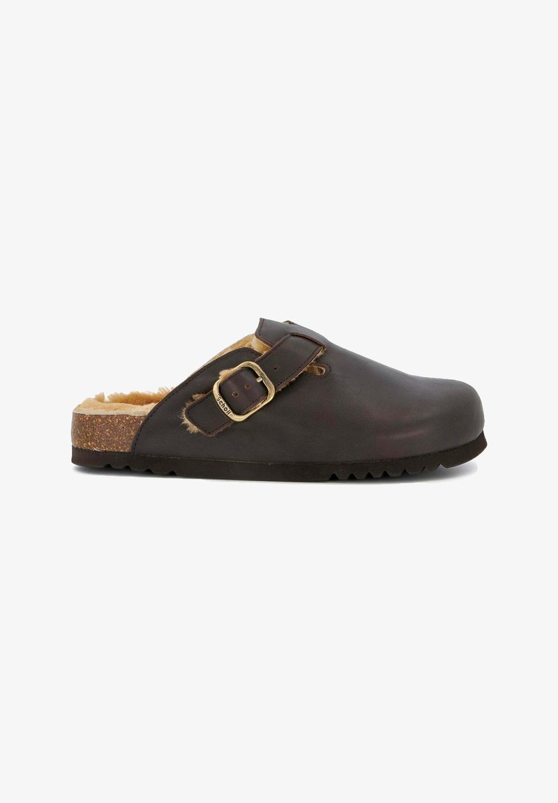 Zueco de cuero marrón con un interior forrado de piel, que presenta una hebilla lateral y una suela gruesa y texturizada. Diseño elegante con una punta redondeada.