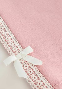 Material roz cu o textură, conturat cu o dantelă albă și accentuat cu un mic fundiță albă pe o parte.