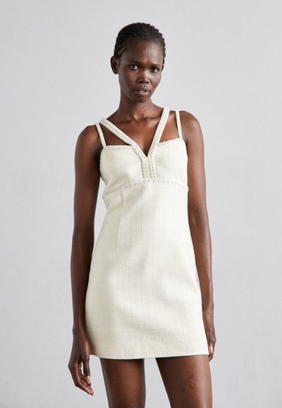 Rochie fără mâneci, de culoare crem, cu material texturat, decolteu în formă de V, accente decorative cu mărgele și bretele subțiri. Siluetă ajustată, cu o lungime scurtă.
