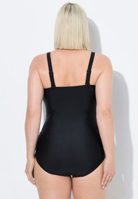 Černé jednodelné plavky s nastavitelnými ramínky, hladkým povrchem a klasickým střihem, s nízkým designem na zádech.