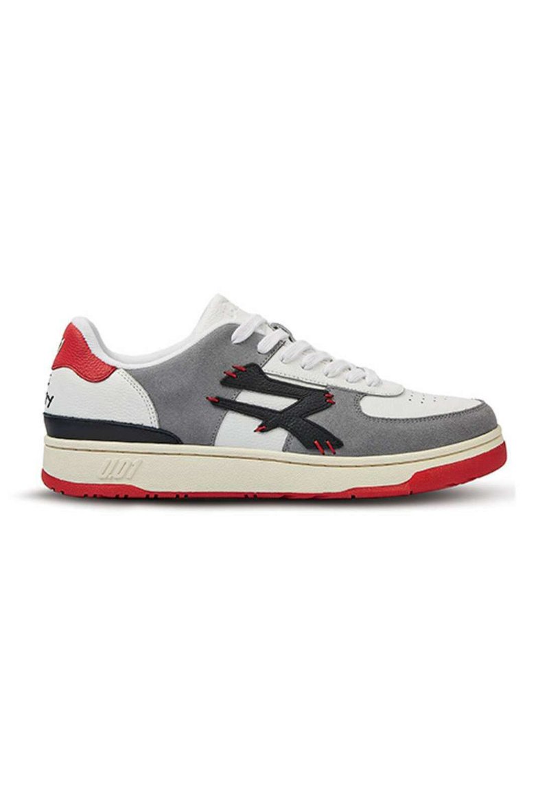 Sneaker grigio, rosso e bianco con una tomaia in suede e pelle, caratterizzato da una suola spessa, accenti neri e dettagli di cucitura prominenti.