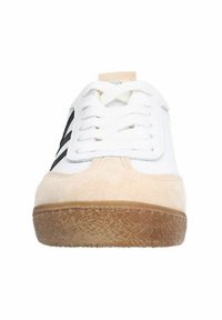 Baskets blanches avec une tige synthétique lisse et un embout en suède beige, comportant des accents rayés noirs et une semelle en caoutchouc texturée.