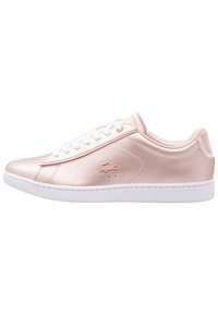 Pink satin sneakers with white laces and rubber sole. Features a Lacoste logo, smooth texture, and minimalistic design.