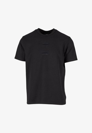 T-shirt nera in cotone con collo rotondo, maniche corte e due toppe decorative rettangolari texturizzate sul davanti.