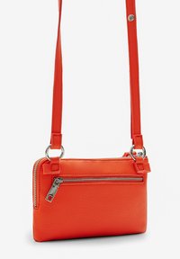 Borsa a tracolla in pelle arancione con chiusura a zip, dotata di una tasca anteriore con zip e hardware in argento. Tracolla regolabile per varie lunghezze.