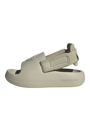 Beżowa klapka Adidas z paskiem wokół pięty i otwartym palcem, z logo Adidas po boku i na wierzchu.