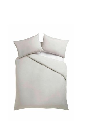 Lit blanc avec deux oreillers et une couette partiellement pliée, vu de dessus sur un fond blanc.