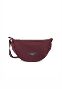 Borsa a tracolla in nylon bordeaux a forma arrotondata, dotata di chiusura con zip, tracolla regolabile e una patch in pelle con logo.