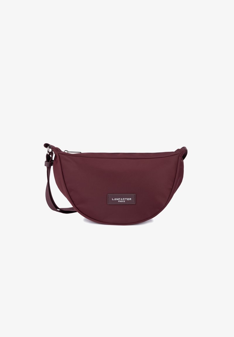 Borsa a tracolla in nylon bordeaux a forma arrotondata, dotata di chiusura con zip, tracolla regolabile e una patch in pelle con logo.