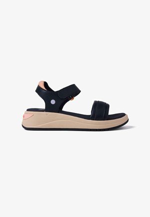 Sandalias de cuero negro con correas ajustables, plantilla acolchada y suela plataforma beige. Presentan detalles en rosa claro y gris.