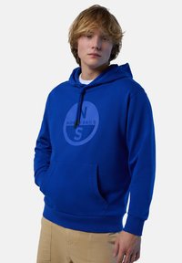 Felpa blu in cotone con tasca frontale, cappuccio con cordino e un logo circolare che presenta il testo "N" e "S" in un colore contrastante.