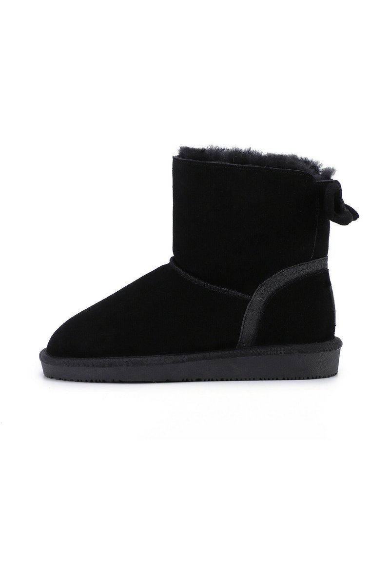 Botines negros de ante suave, con un interior acolchado, suela de goma y un detalle de lazo decorativo en la parte trasera.